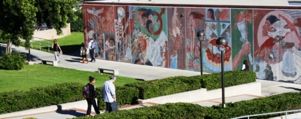 Students walking in front of mural depicting ethnic diversity